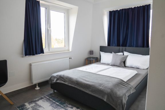 Doppelzimmer mit dunklen Vorhängen im Hotel Schenk