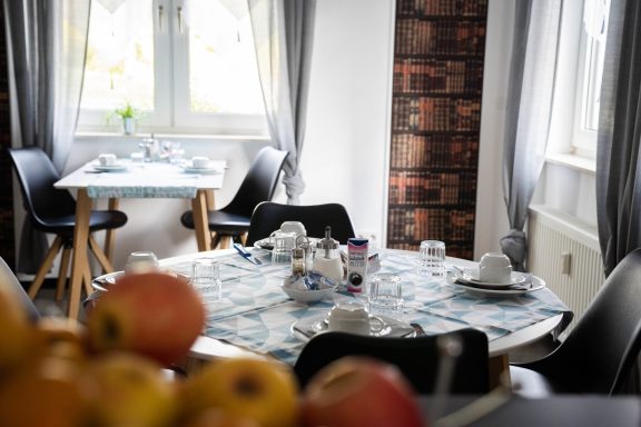 Frühstücksraum mit gedeckten Tischen im Hotel Schenk