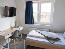 Einzelzimmer mit Bett und Fenster im Hotel Schenk